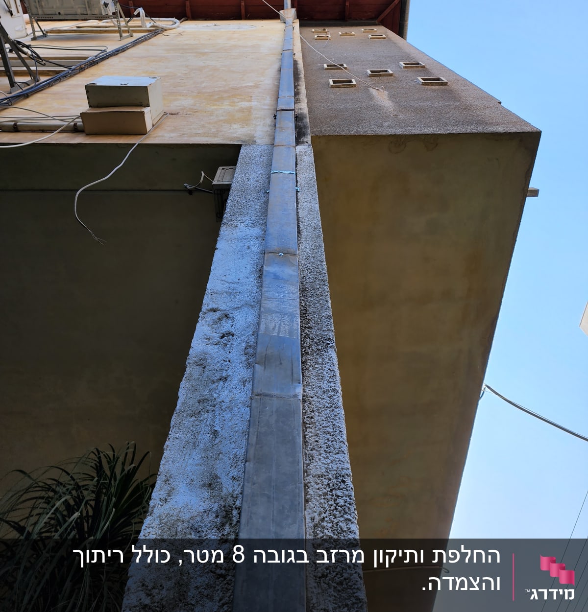 צינור מתכת על קיר בניין מתחת לגג